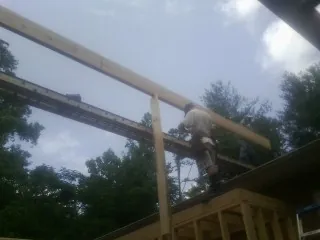 Carpenter setting a ridge beam over a new addition frame — Ice Dam Removal by Roofing Brothers in Leetsdale