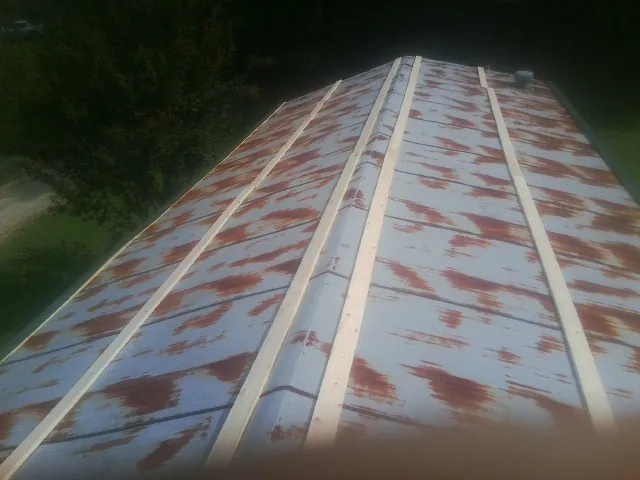 Rusted metal roof panels with new wood purlins before replacement — Storm Damage Roof Repair in Leetsdale by Roofing Brothers
