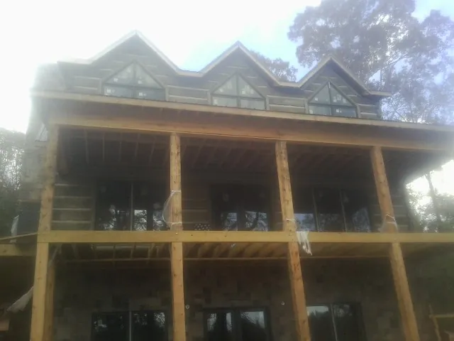 Dormers and porch framing on a large log home under construction — Roof Coating work by our crew in Leetsdale