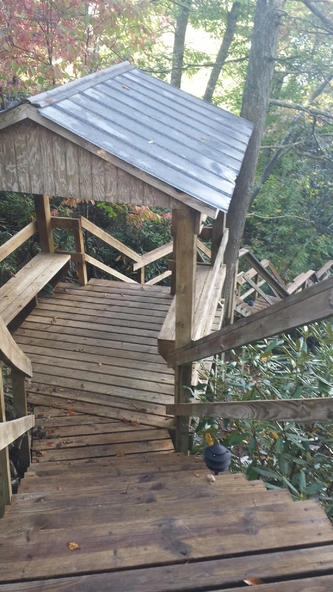 Metal roofed shelter over wooden steps on a wooded walkway — Skylight Repair & Installation work by our crew in Leetsdale