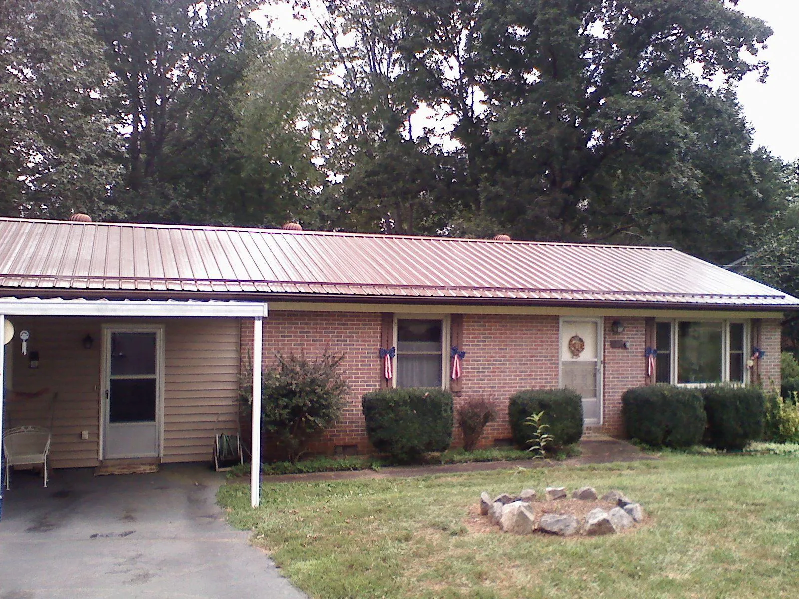 Bronze metal roof and carport on a brick ranch home — Roof Repair work by our crew in Leetsdale